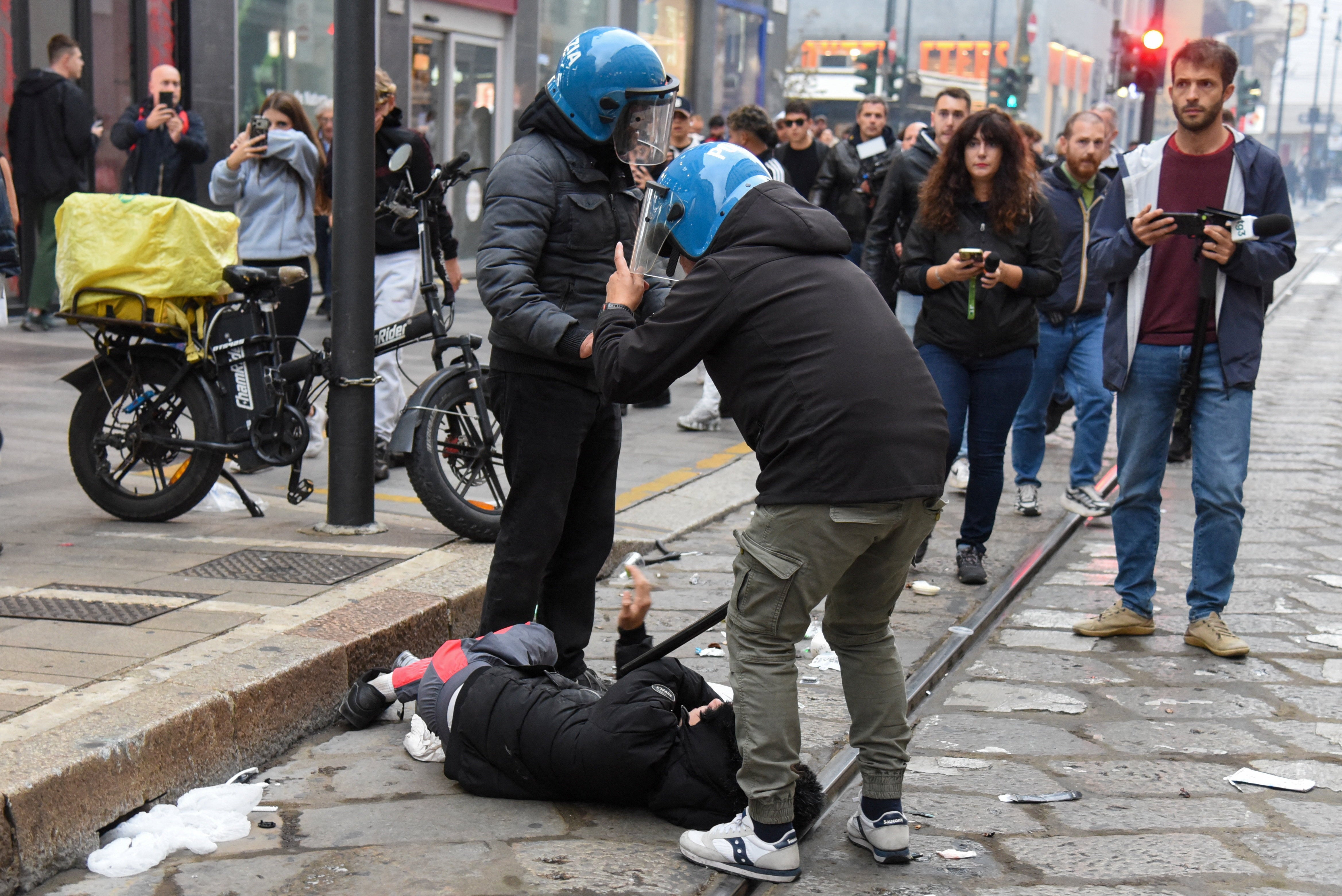 La policía italiana detiene a un manifestante durante una protesta contra el deterioro de los servicios públicos y el aumento del costo de vida en Milán