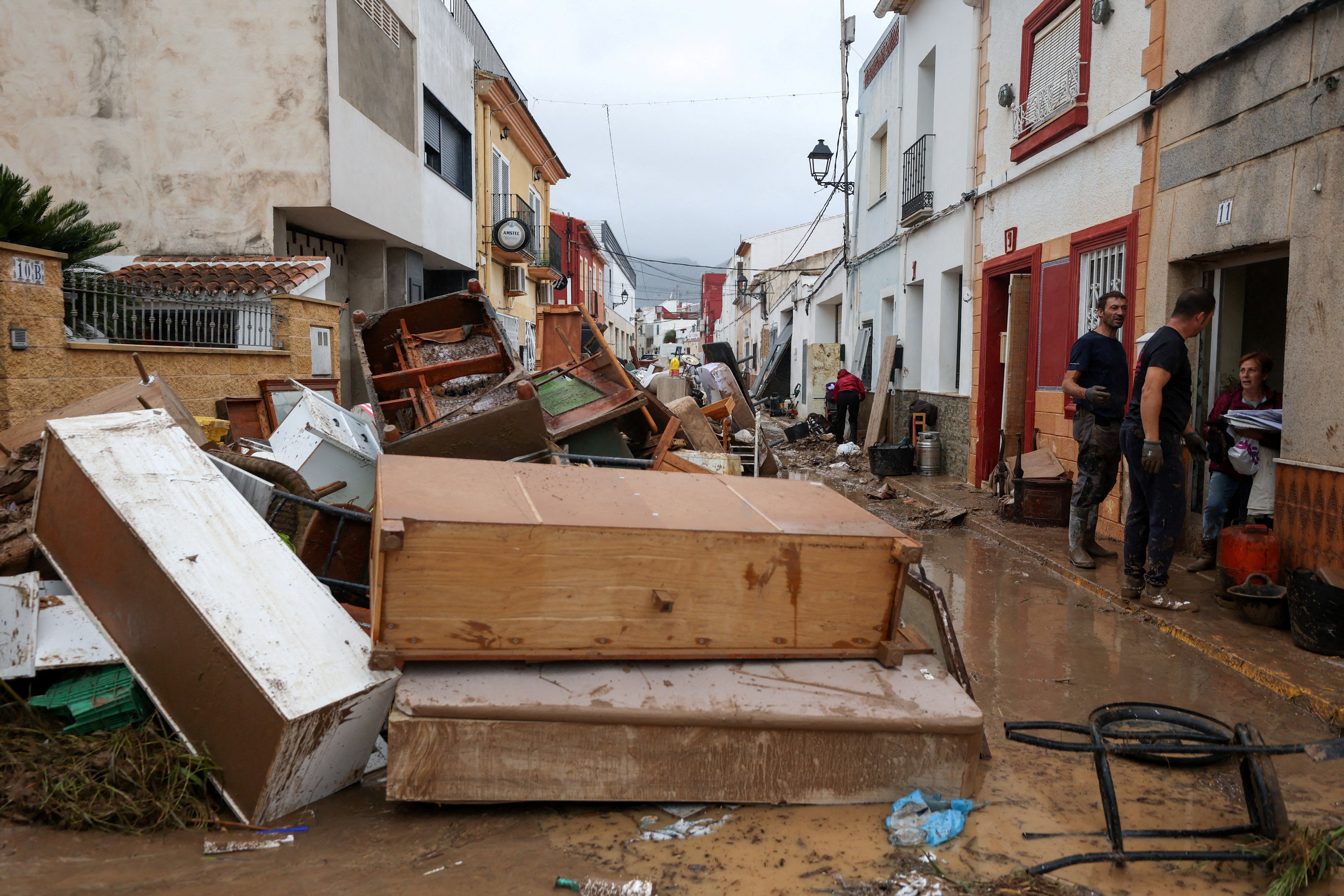 <p>Pertenencias de residentes sobre una calle cubierta de barro tras las lluvias torrenciales que provocaron inundaciones en el este de España</p>