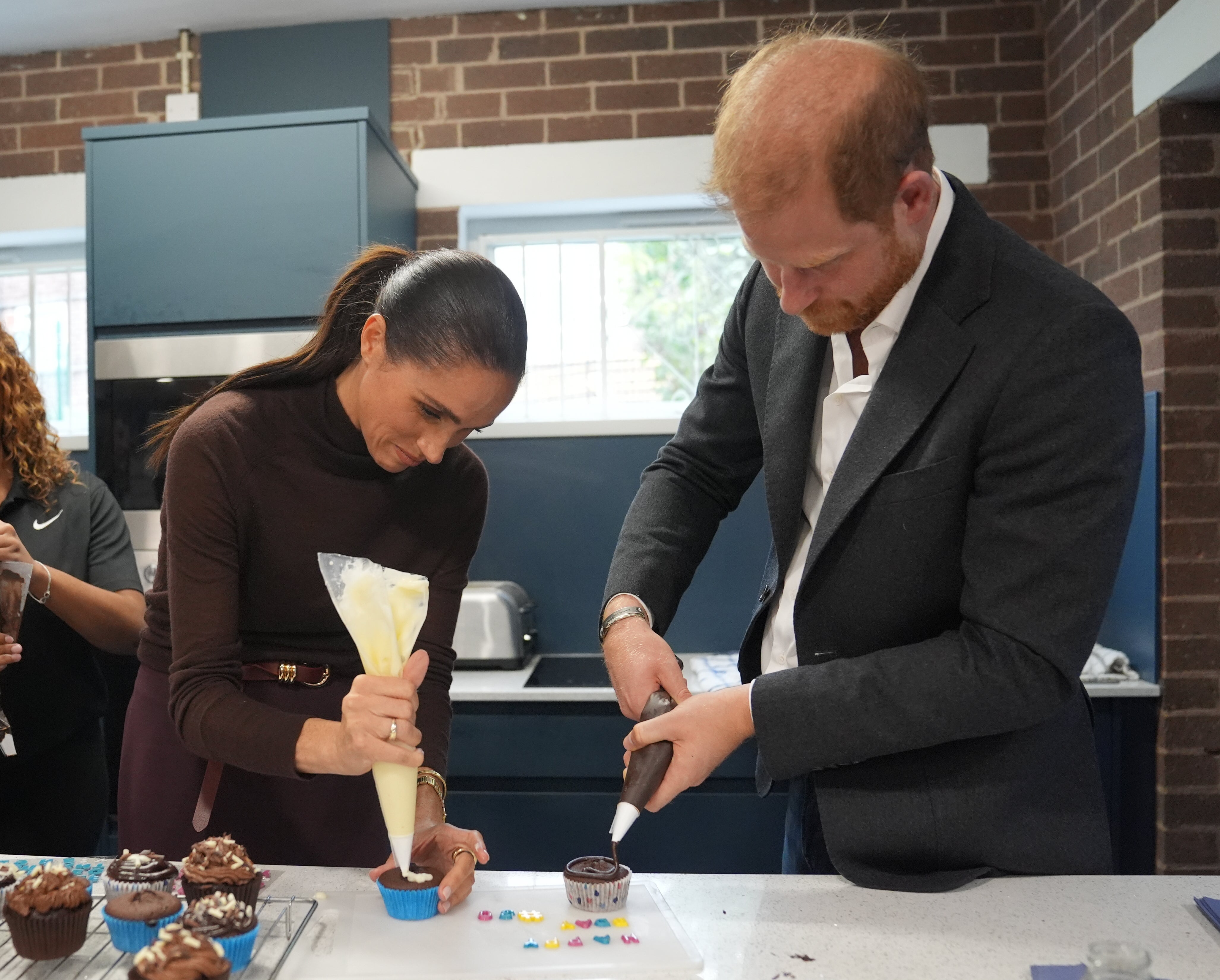 Meghan, duquesa de Sussex, y el príncipe Harry, duque de Sussex, decoran magdalenas en la organización sin fines de lucro Epic Partners durante su visita a Nottingham, Inglaterra