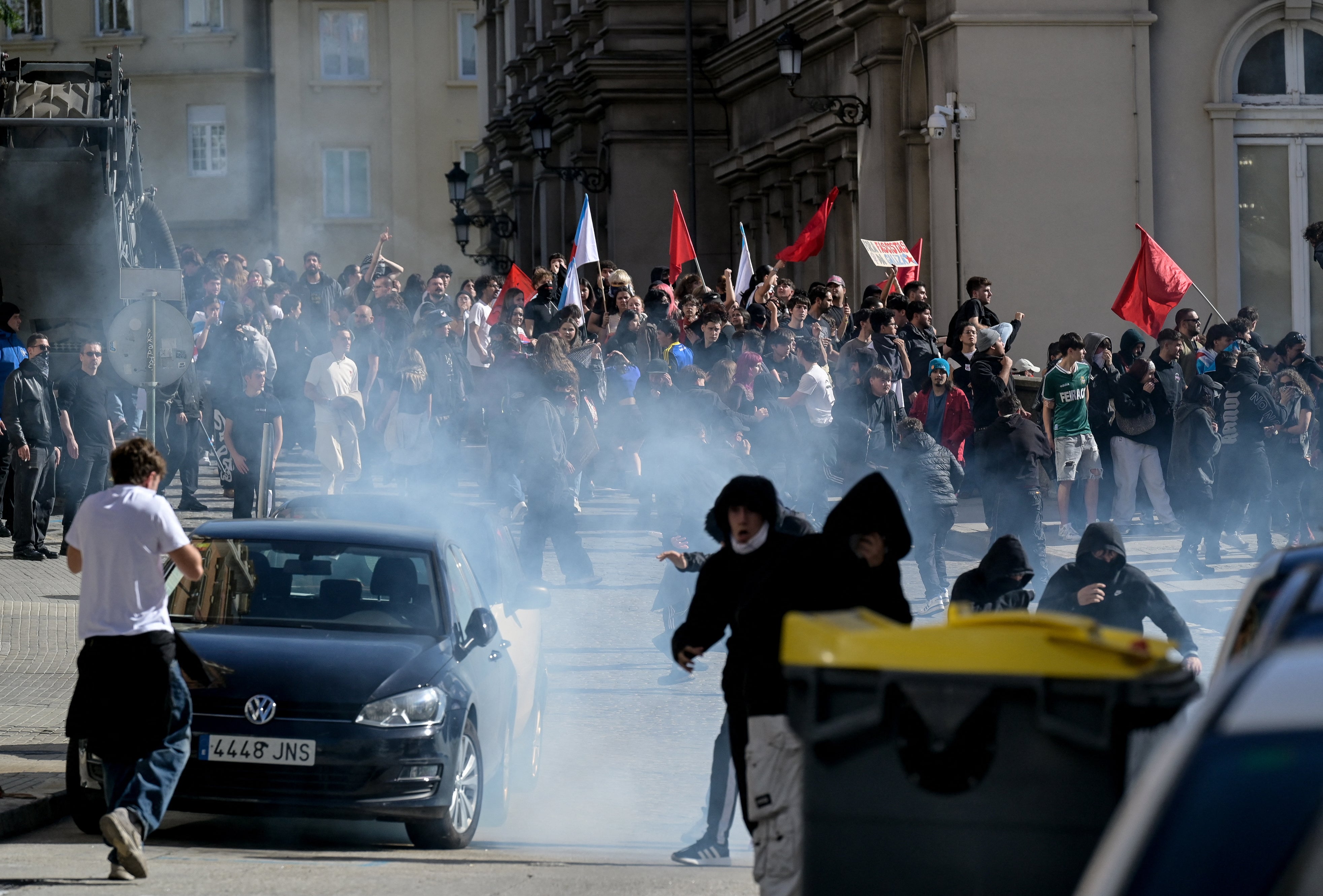 Los manifestantes reaccionan ante el gas lacrimógeno mientras participan en una manifestación en la ciudad este miércoles