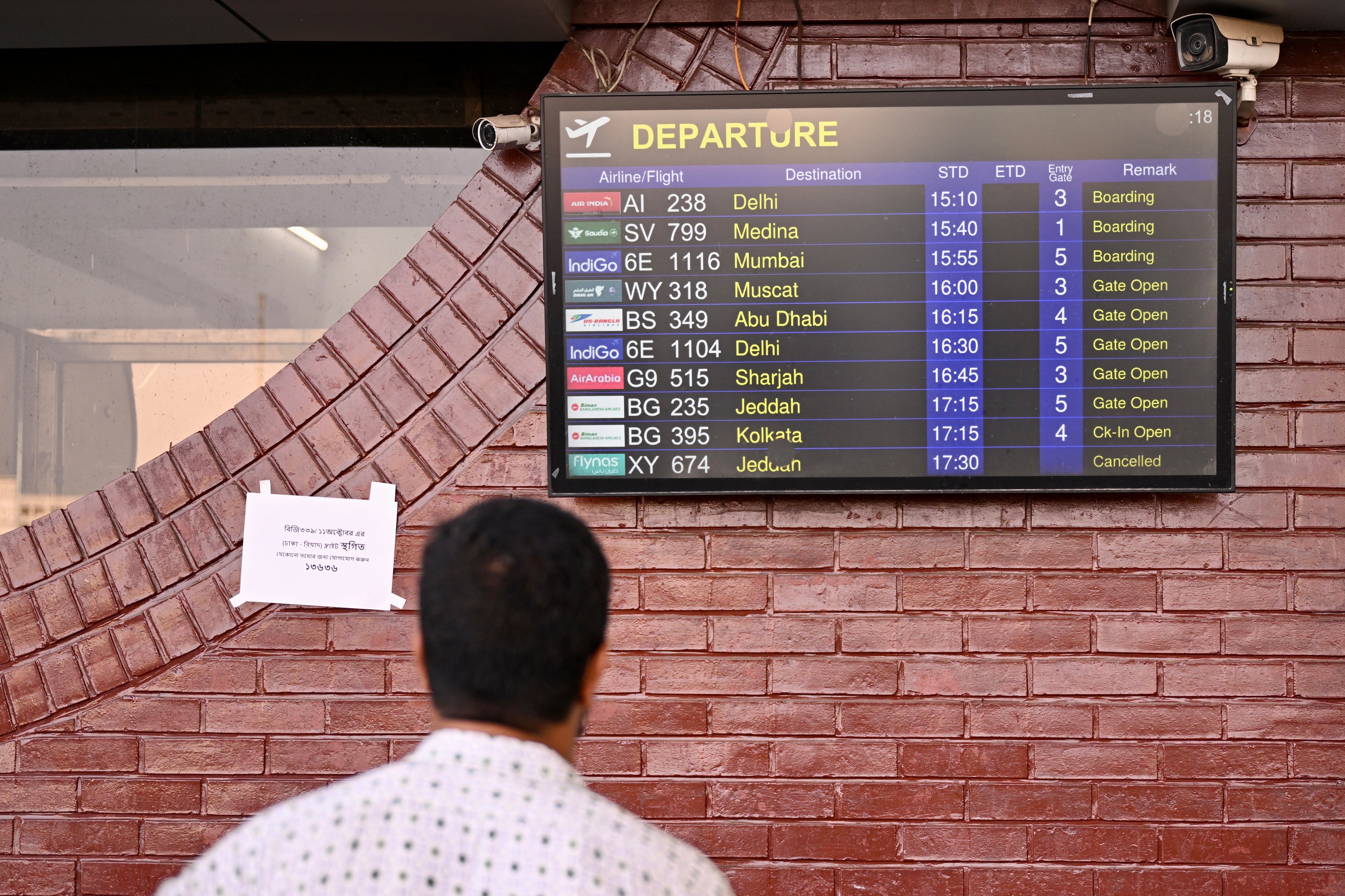 Un hombre consulta las pantallas de vuelos del Aeropuerto Internacional Hazrat Shahjalal de Daca, Bangladesh, el 12 de octubre de 2026, mientras permanecen cancelados los vuelos con destino a Arabia Saudita, un día después de un ataque de los hutíes contra el aeropuerto internacional de Riad