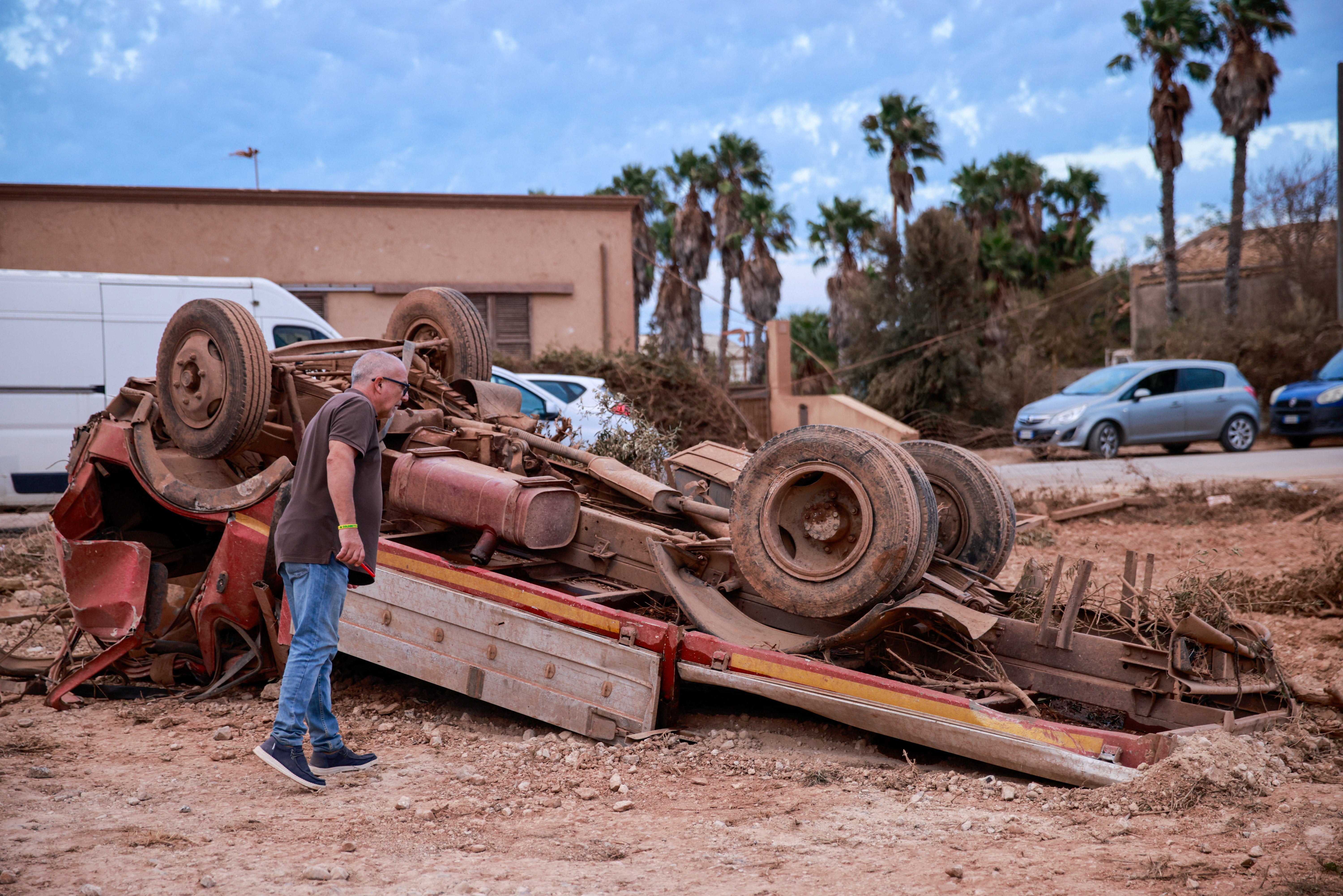 Un hombre observa un camión volcado tras el paso de un tornado por Marsala, una ciudad de la costa occidental de Sicilia