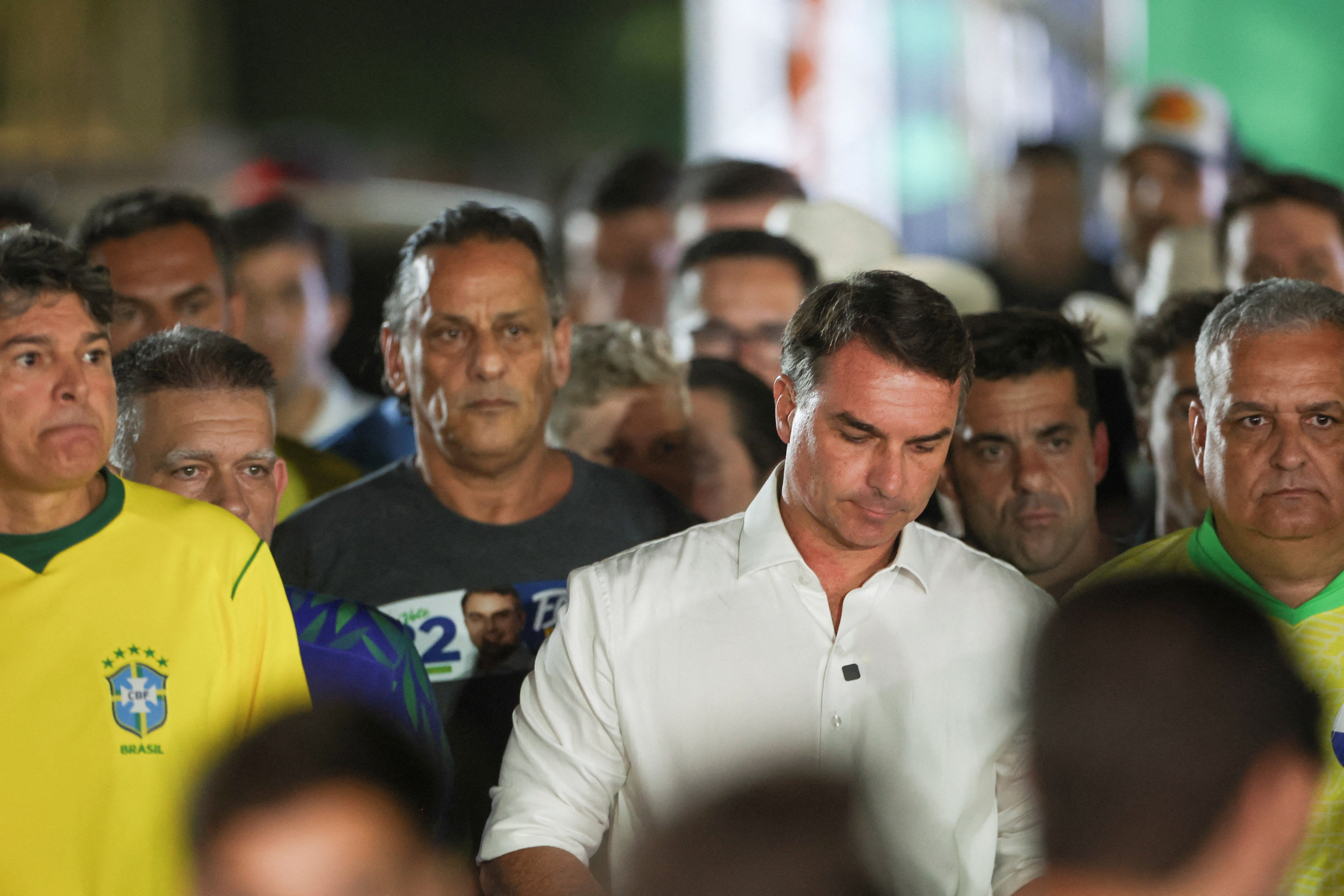 Flavio Bolsonaro, que aparece en la foto vestido de blanco, cuestionó la decisión de ampliar el horario de votación en dos horas