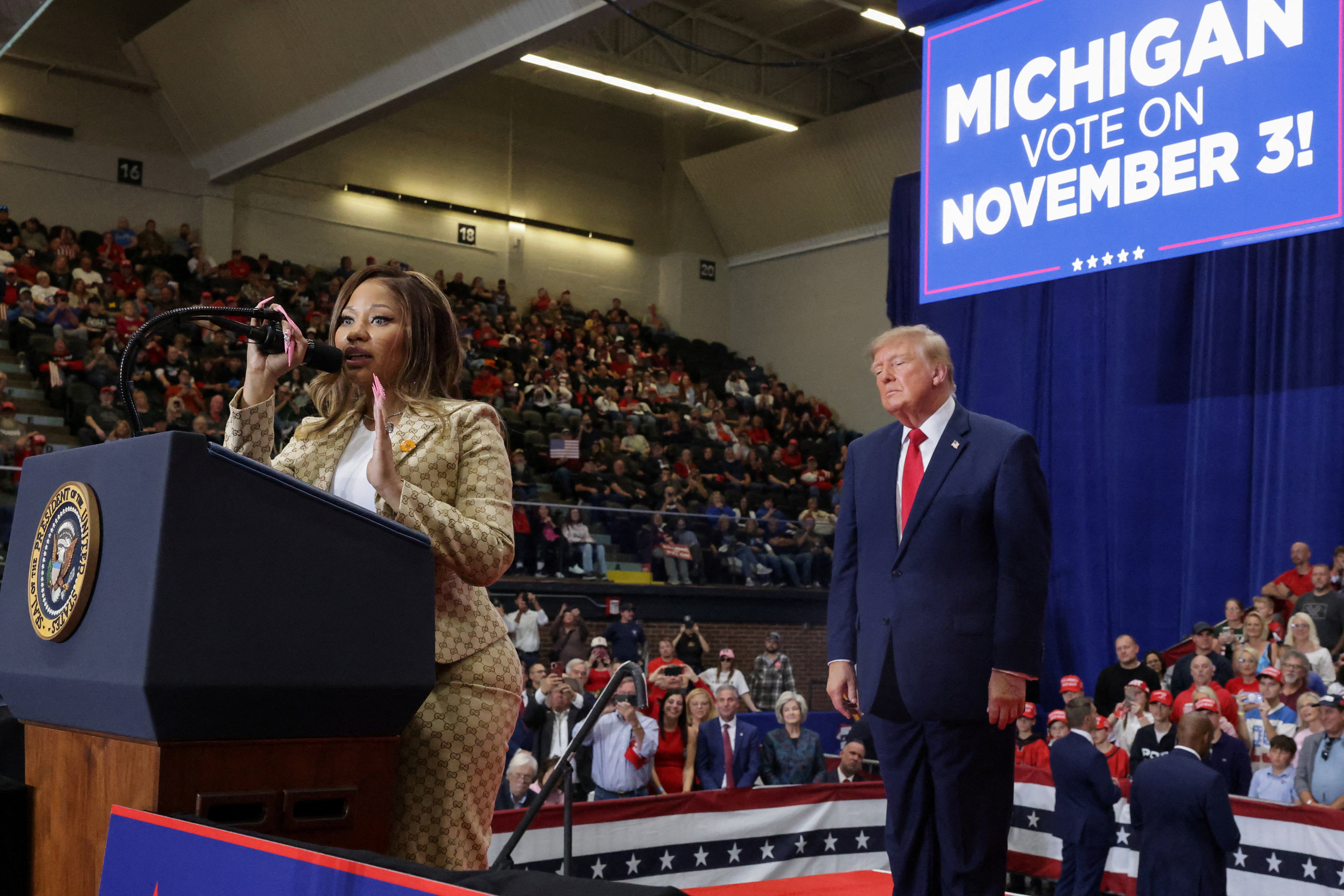 Trump escucha atento a Nicki Minaj durante un mitin en apoyo a Mike Rogers, celebrado el domingo en Port Huron, Michigan