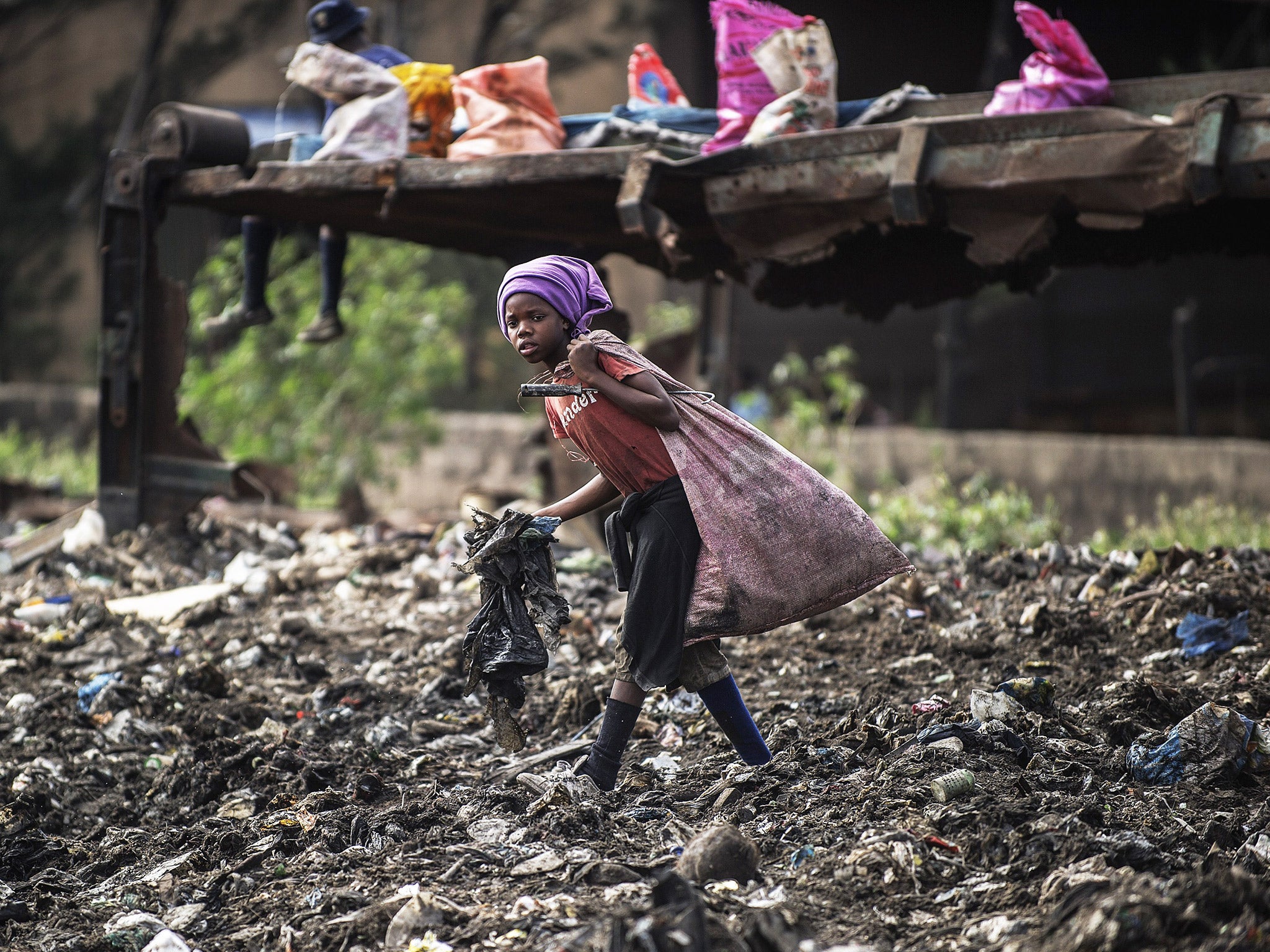 Una niña recoge basura en un vertedero en Maputo, Mozambique