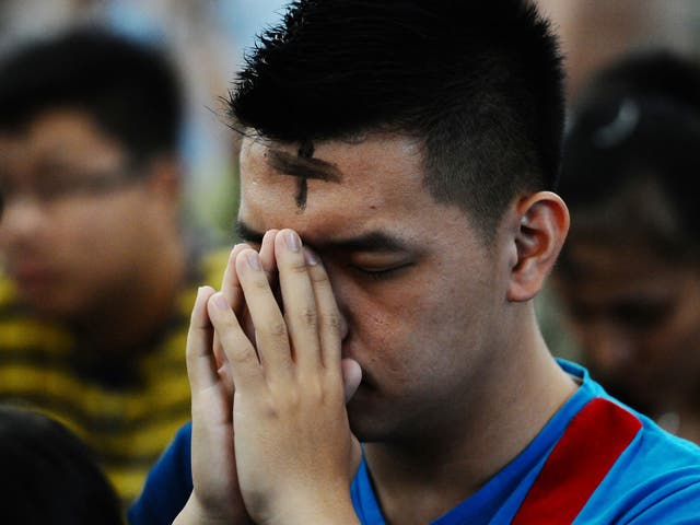 <p>A Catholic man prays during the Ash Wednesday ceremony at Roh Kudus Church on March 5, 2014 in Surabaya, Indonesia.</p>