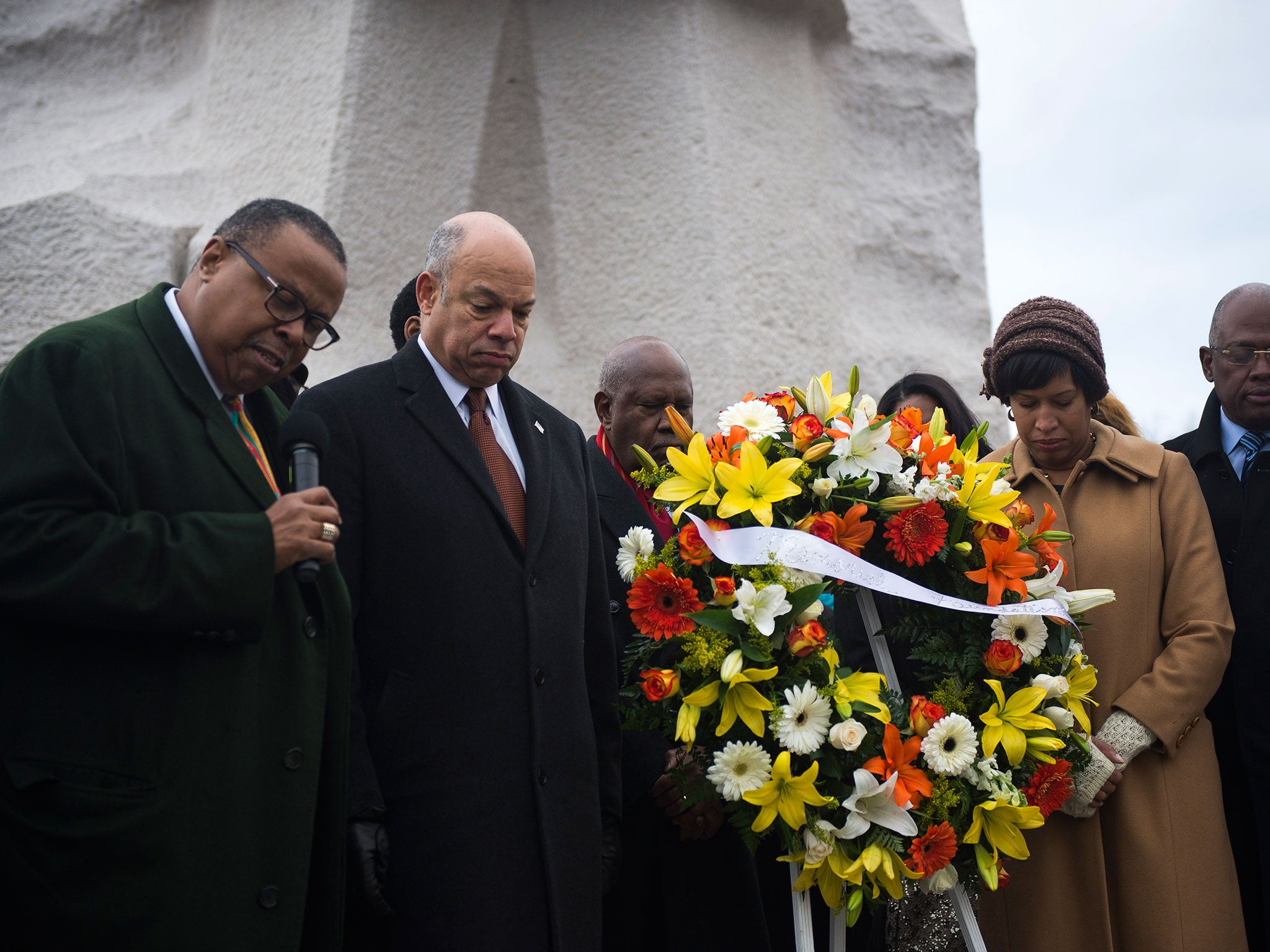 El secretario de Seguridad Nacional y el alcalde de Washington DC, junto con el presidente y director general de la Fundación Martin Luther King Jr. Memorial, dejan una corona de flores en el monumento a MLK durante una ceremonia en el National Mall, en Washington DC, en 2015