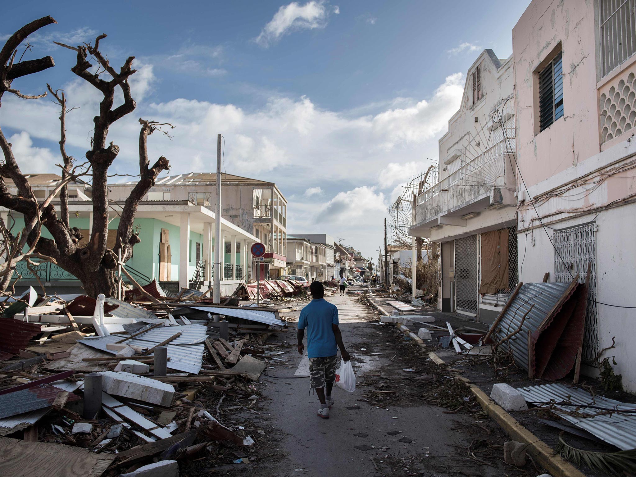 Un hombre camina sobre una calle llena de escombros en la isla de San Martín
