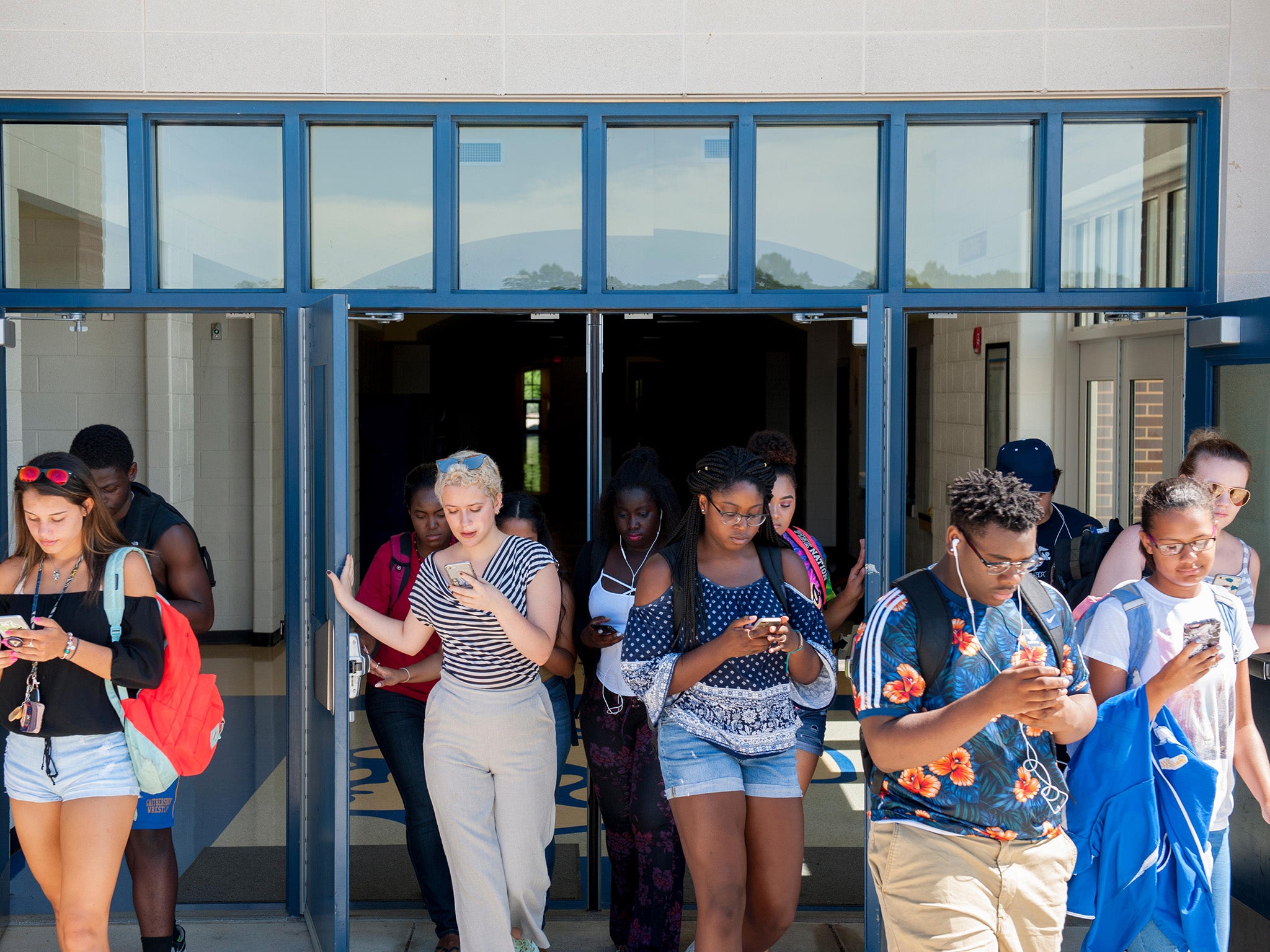 Adolescentes al teléfono al salir de clase