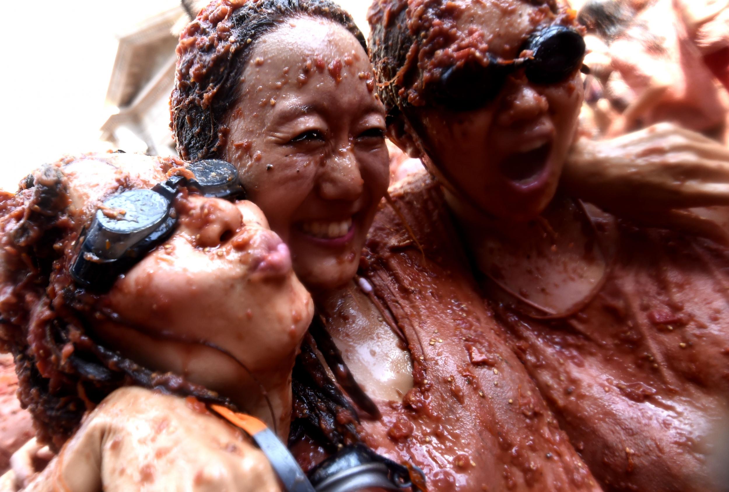 Revellers, covered in smashed tomatoes, take part in the 'Tomatina' festival in Bunol