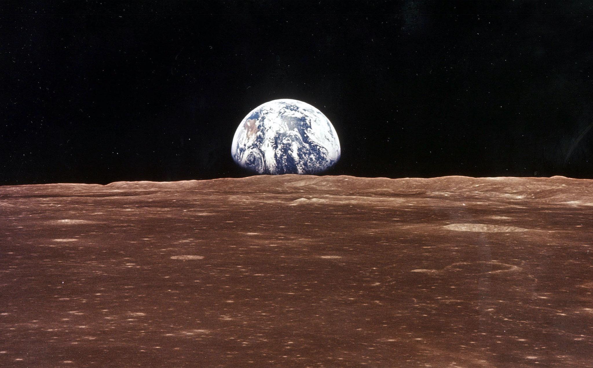 Aparece una imágen de la Tierra sobre el horizonte lunar cuando el Módulo de Comando del Apolo 11 aparece en el campo de visión de la Luna