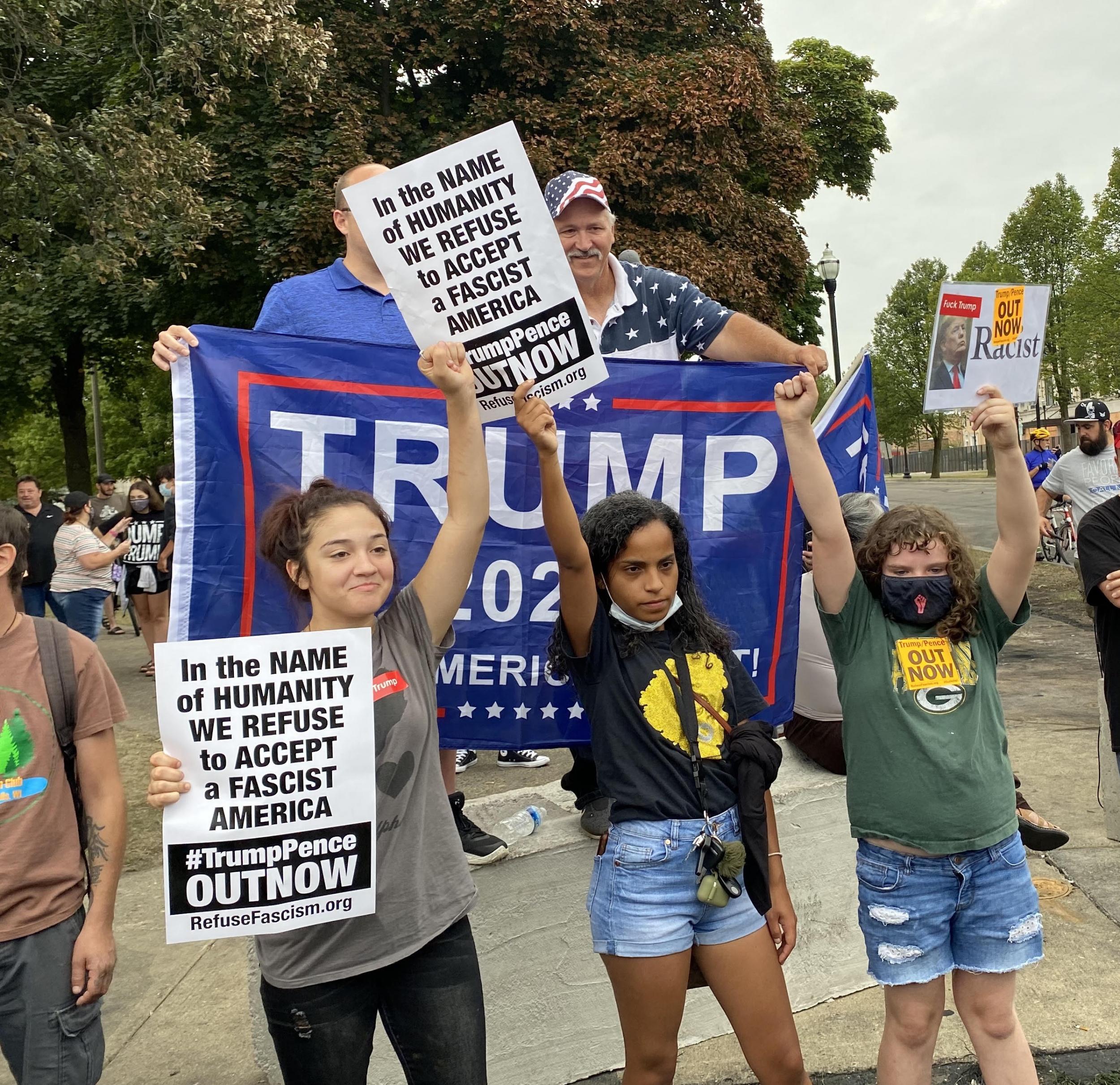 Protestantes se paran frente a los seguidores de Trump durante la visita del presidente a Kenosha, Wisconsin.